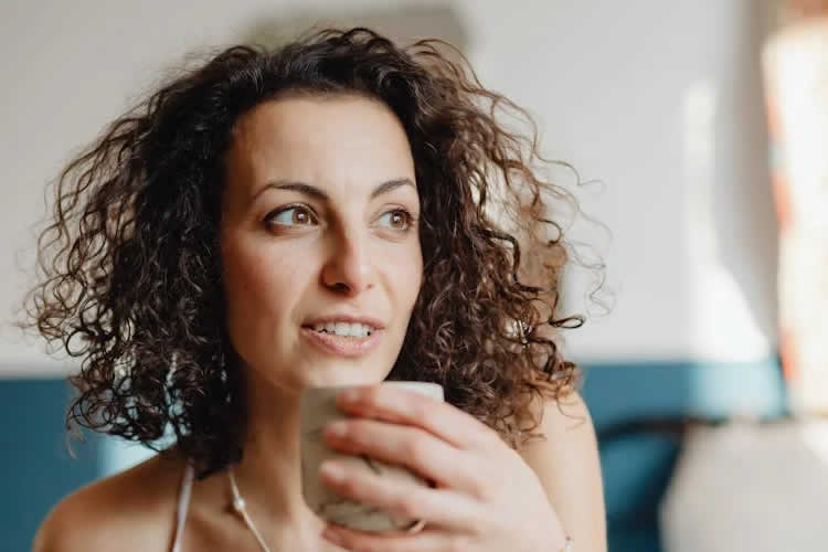 A young woman enjoying a cup of coffee in a cozy café setting