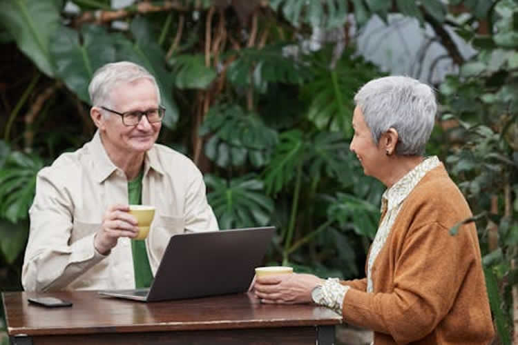 An older gentleman enjoying a pastry and coffee wit a companion