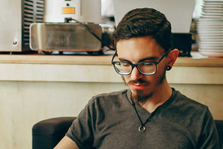 A Young Man Reading in a Cafe